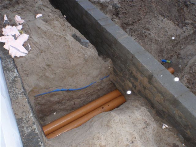 Wyjście ze ściany fundamentowej i przejście pod tarasem rur pcv do montażu gwc.