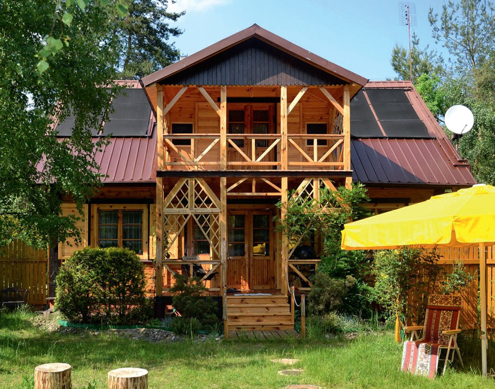 Drewniany dom z kolektorami słonecznymi