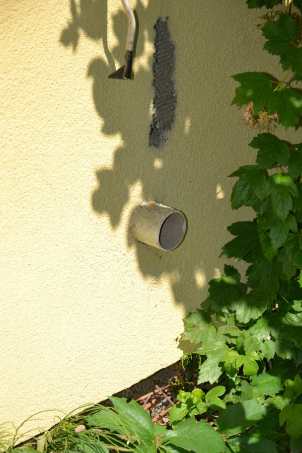 Wylot wyrzutni powietrza przez ścianę w garażu