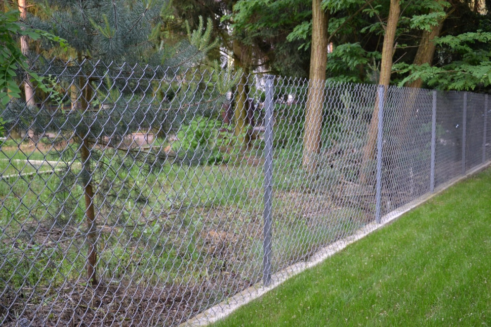 Bok działki ogrodzono siatką, rozpiętą na słupkach