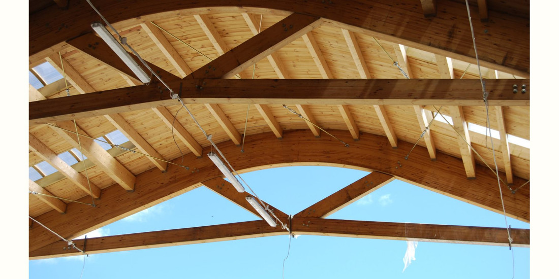 Drewniana konstrukcja dachu hali produkcyjnej w Suszu