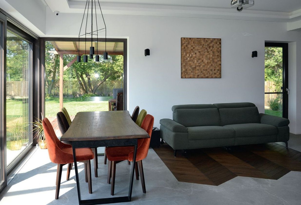 Salon jest oświetlony światłem wpadającym przez narożne okno, a po zmroku - różnorodnym oświetleniem