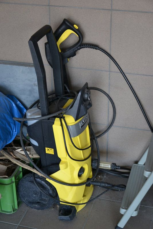 Myjka ciśnieniowa to podręczne narzędzie, przechowywane w garażu.