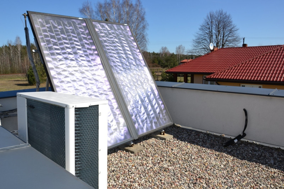 Na płaskim dachu nad garażem zamontowano kolektory słoneczne i klimatyzator