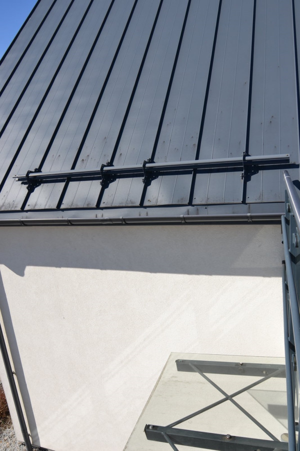 Na dachu, nad szklanym daszkiem nad wejściem do budynku, umieszczono płotek śniegowy w kształcie drążka