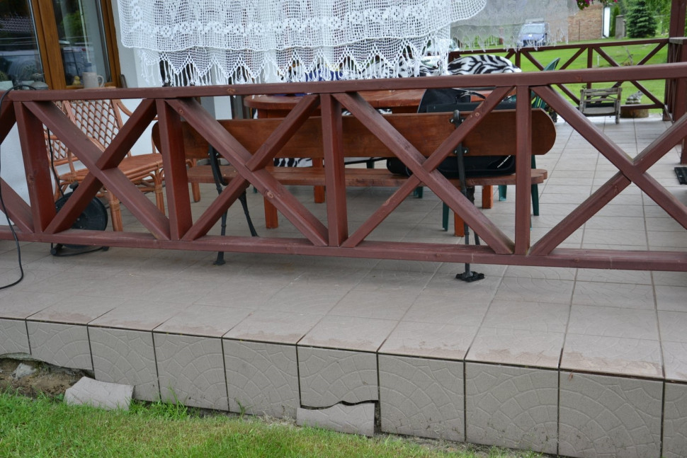 Niechlujnie wylana płyta z betonu i układanie płytek na placki kleju to powody odpadania płytek na bokach tarasu