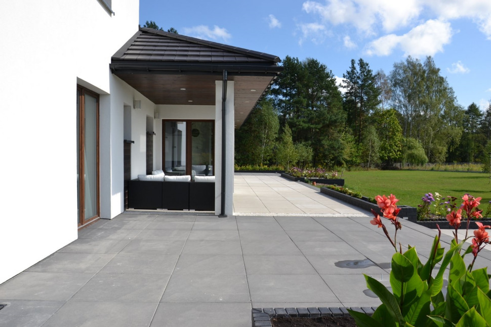 Taras wzdłuż całej tylnej ściany domu zbudowano z płyt betonowych w kolorze popielatym i antracyt