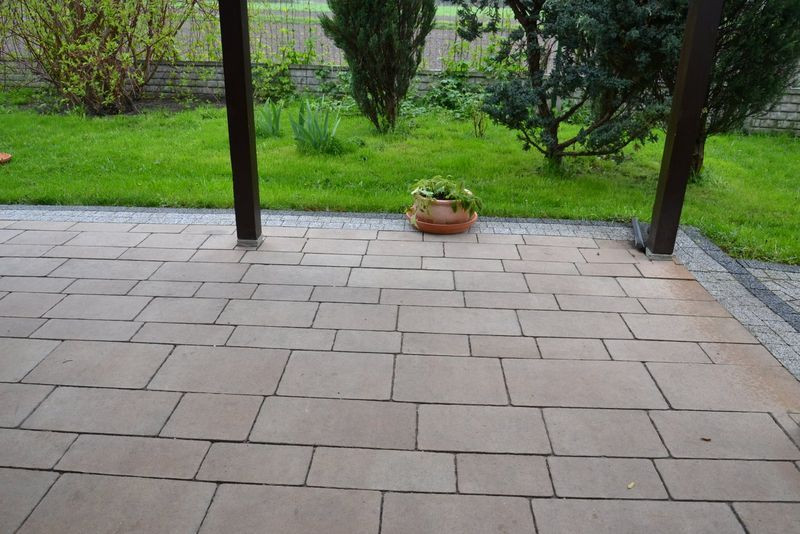 Nawierzchnia z różnej wielkości betonowych płyt, imitujących piaskowiec. Obrzeże - z kostki betonowej, udającej granit (jak na ścieżkach)