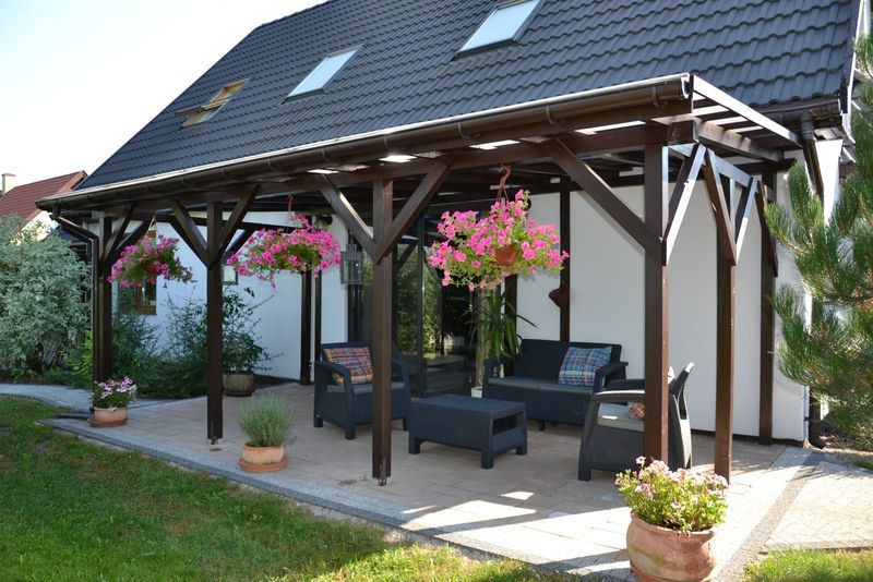 Taras na gruncie osłania pergola, zadaszona płytami poliwęglanu