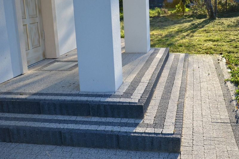 Prostokątne schody na ganku wykończono innymi kształtkami z betonu, bez dużych szpar