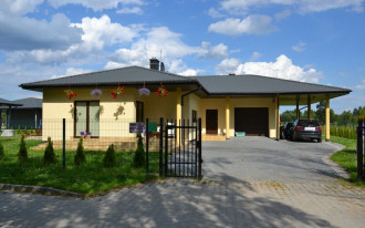 Parterowy dom z zadaszoną wiatą i dwoma tarasami