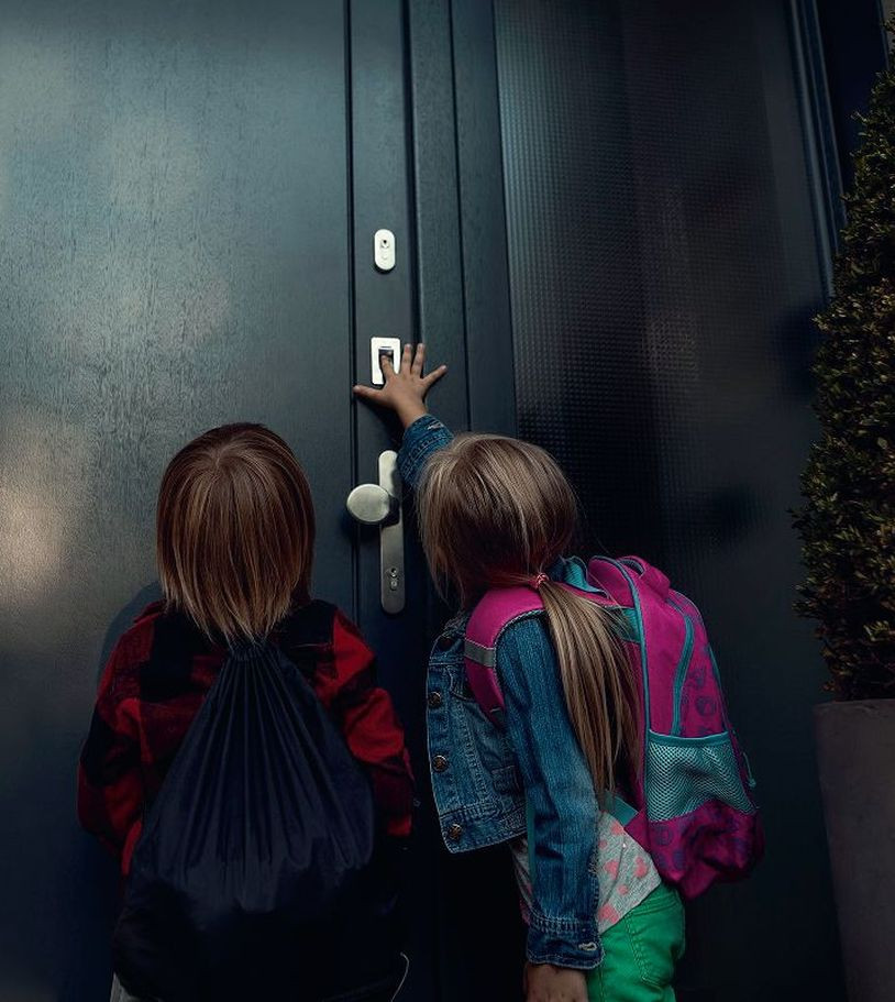 Dzieci korzystające z czytnika linii papilarnych na drzwiach zewnętrznych