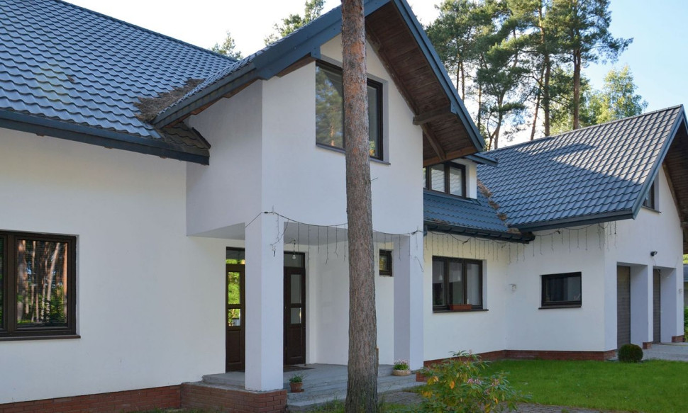 Dom ma tradycyjną bryłę, przykrytą wielospadowym dachem z lukarnami