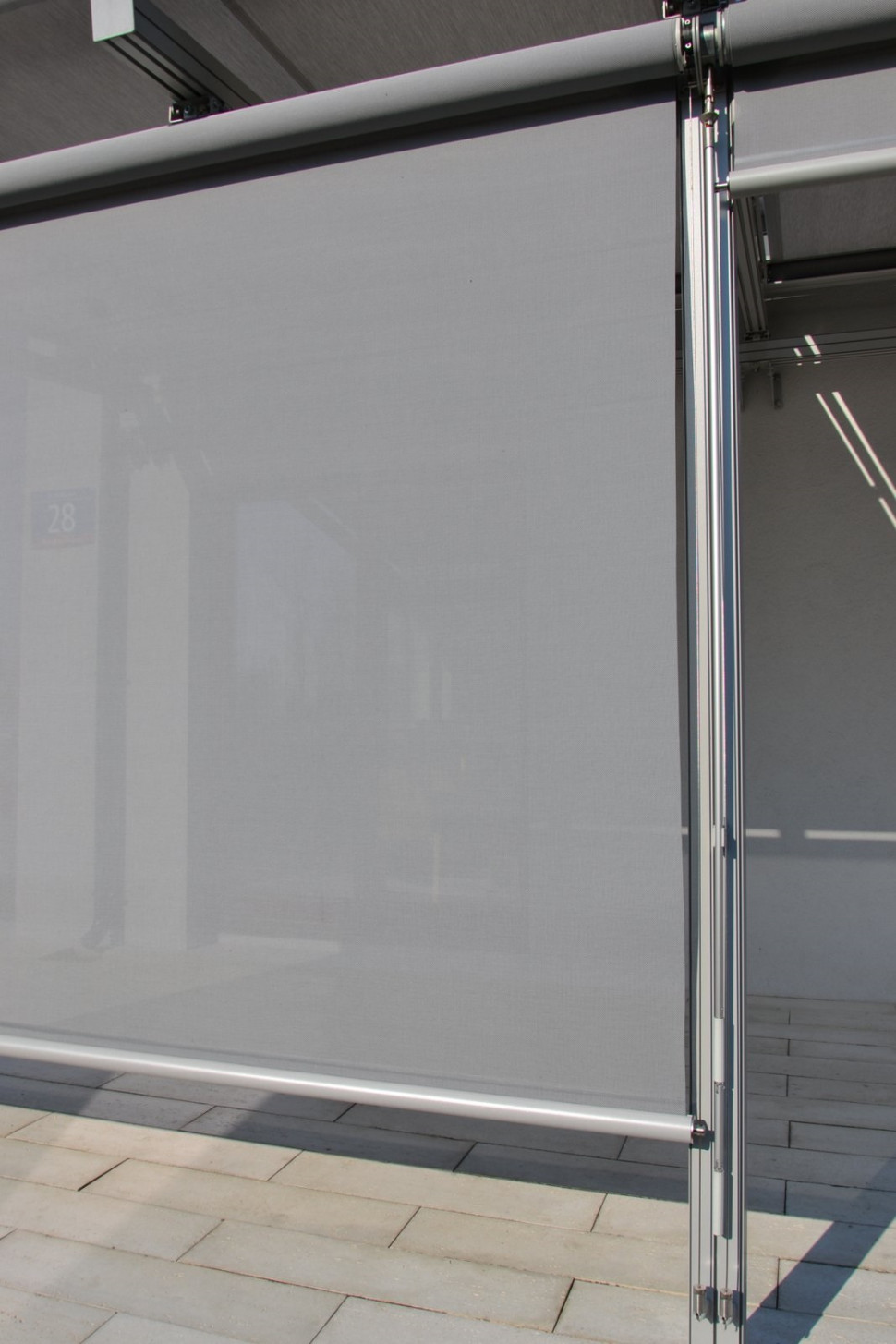 Boczne markizy na południowej ścianie pergoli łopoczą podczas wiatru, choć są przymocowane do stalowych linek