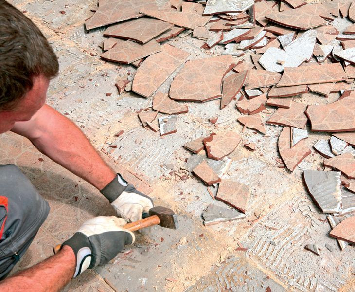 Usunięcie starych płytek tarasowych korzystając z młotka i przecinaka