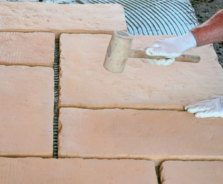 Okładzinę dociska się do podłoża i delikatnie dobija gumowym młotkiem, żeby osiągnąć równą płaszczyznę