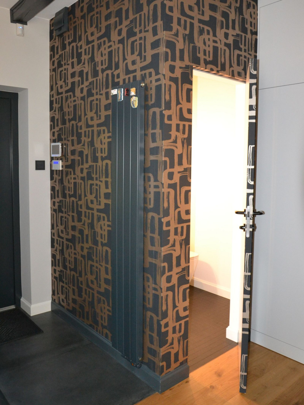 Łazienka znajduje się wewnątrz kubika wykończonego wzorzystą tapetą