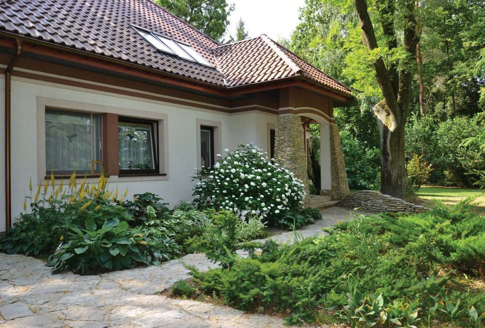 Rabaty przy domu właściciele obsadzili wytrzymałymi bylinami (m.in. funkiami, języczkami, paprociami) i krzewami (hortensjami, jałowcami)