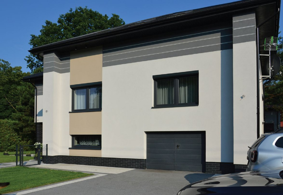 Geometryczne podziały, wyrobione z tynku silikatowego w kilku kolorach, i boniowanie tuż pod dachem optycznie obniżają wysokie elewacje.