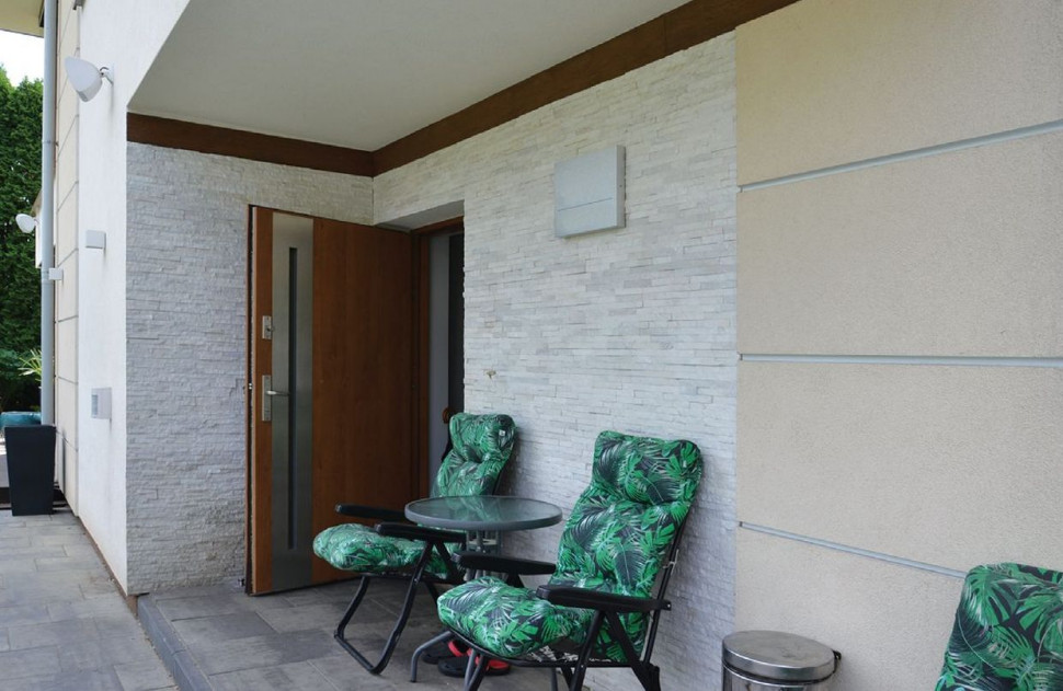 Ściany we wnęce wejściowej właściciele ozdobili okładziną z jasnego kamienia oraz boniowaniem