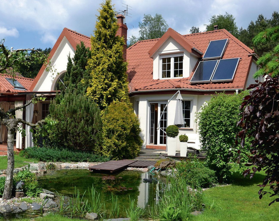 Ogród z oczkiem wodnym, kolektory słoneczne na dachu