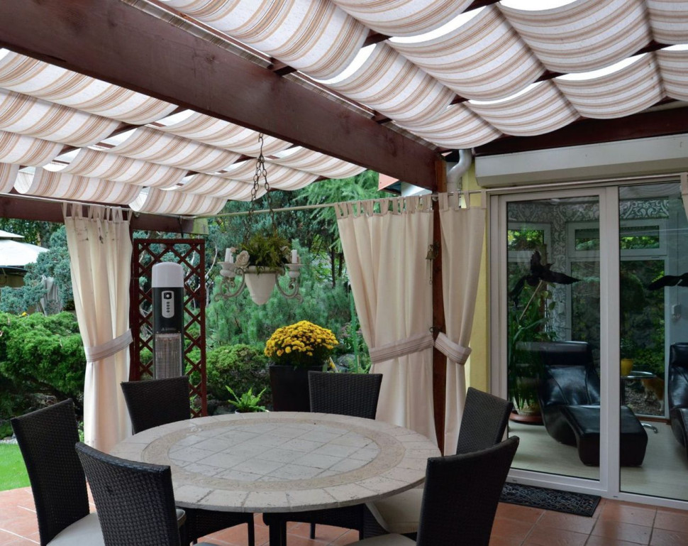 Do głównego tarasu z zadaszeniem przylega ogród zimowy