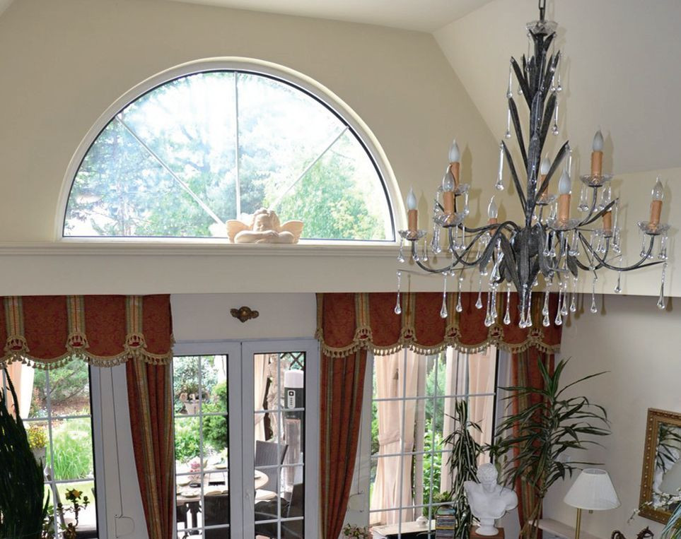 Katedralny sufit nad salonem o wysokości dwóch kondygnacji i okno z łukiem