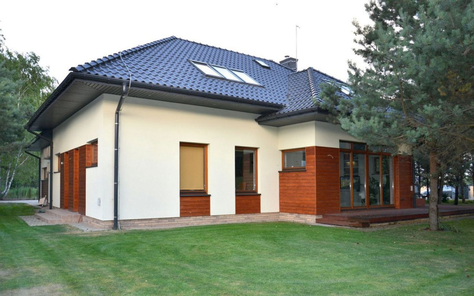 Dom z tradycyjną bryłą przykrywa czterospadowy dach, pokryty dachówką ceramiczną