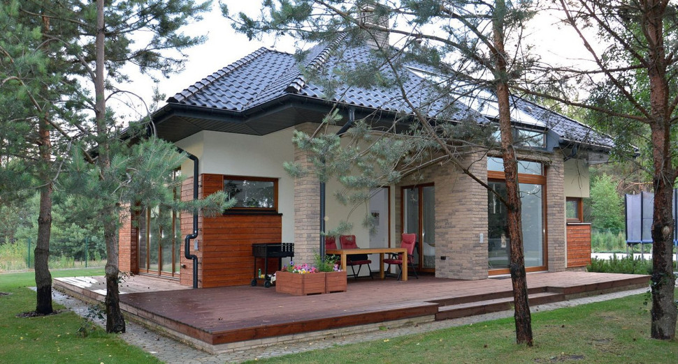 Strefę dzienną na parterze otacza, powiększony przez właścicieli, narożny taras