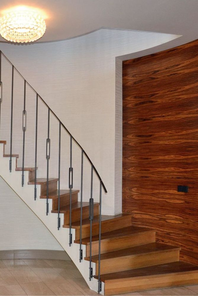 Reprezentacyjny wewnętrzny hol ozdabia kręta zabiegowa klatka schodowa z dyskretną balustradą ze stali