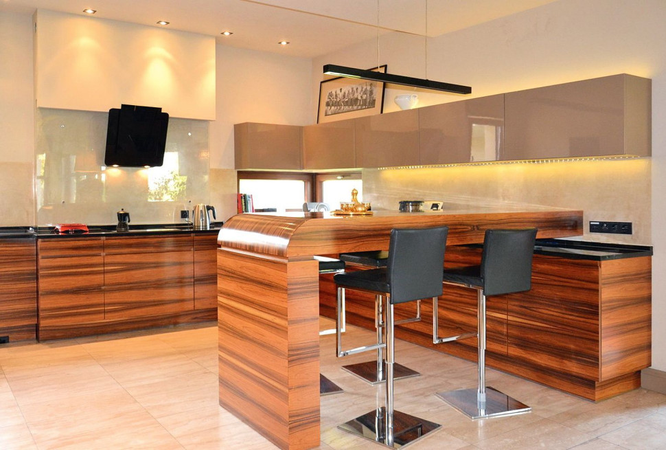 Kuchnia ma zabudowę w kształcie litery L i barek