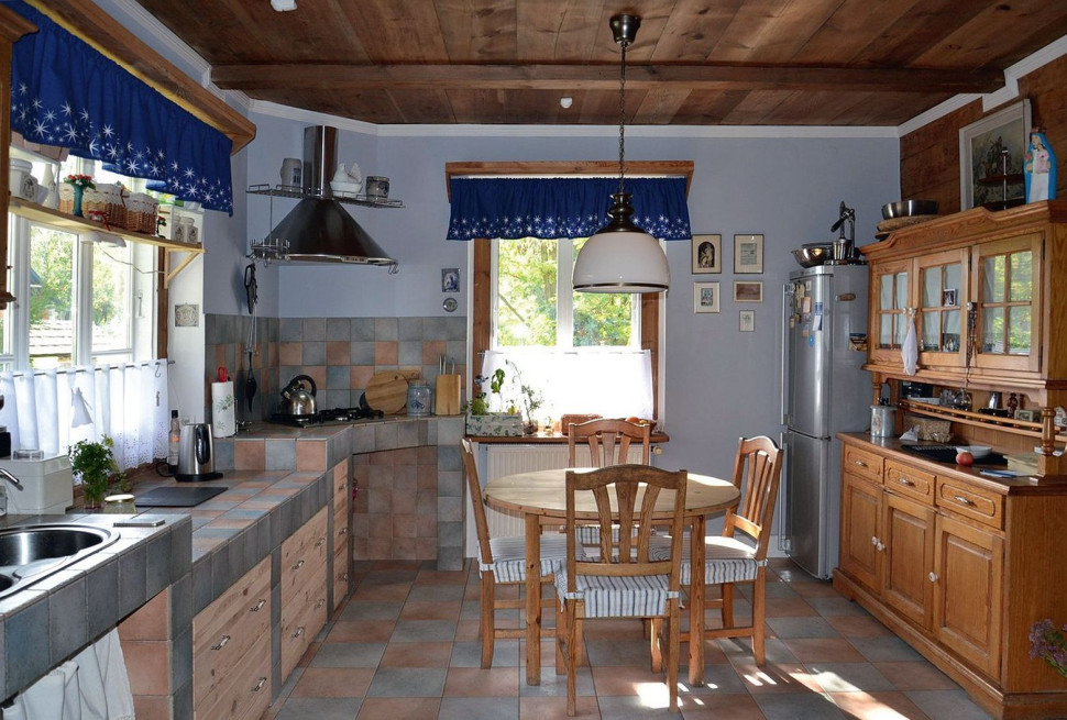 Obszerna kuchnia z widokiem na wjazd i drogę urządzona w stylu rustykalnym