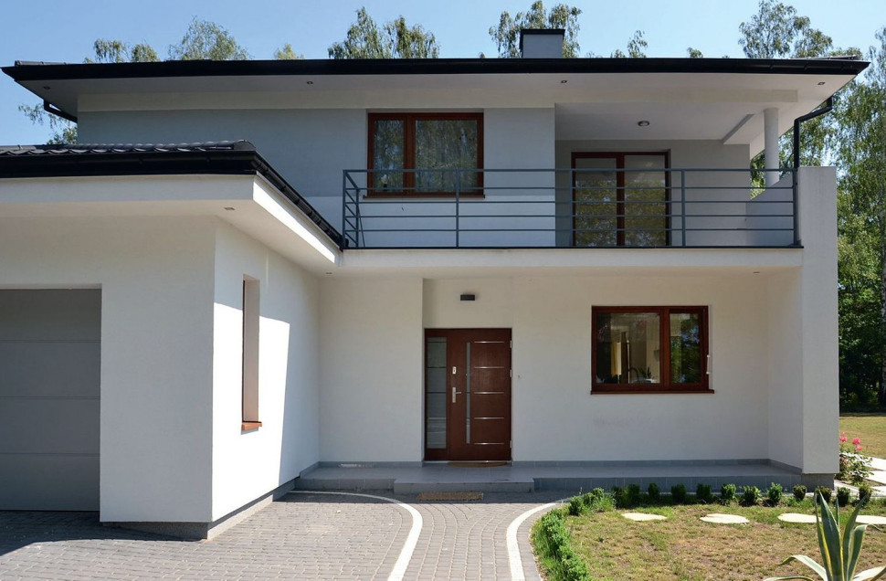 Szerokie i wykonane z drewna oraz szkła drzwi wejściowe