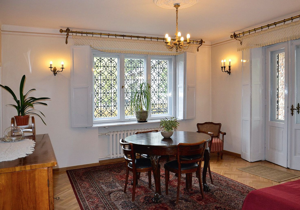 Stare okna z wewnętrznymi okiennicami i parkiet z klepek dębowych w jadalni