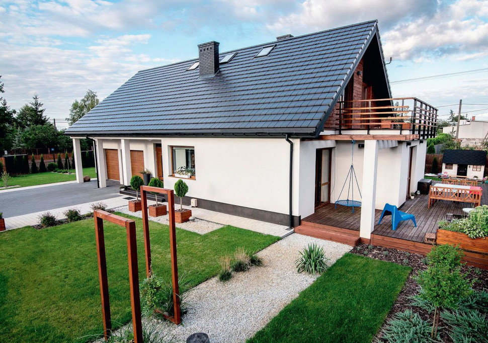 Zimną, nowoczesną kolorystykę domu ociepla drewniana okładzina ścienna na poziomie poddasza oraz deski tarasowe (z modrzewia syberyjskiego)