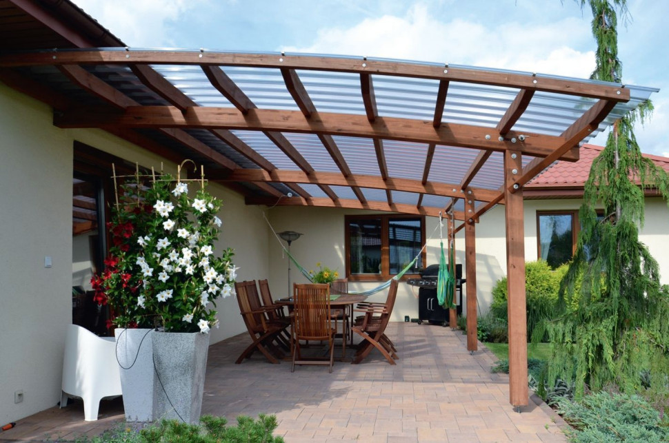 Konstrukcję nad tarasem, z klejonej kantówki sosnowej, wieńczy wygięty w łuk dach i pokrycie z przezroczystych płyt poliwęglanu