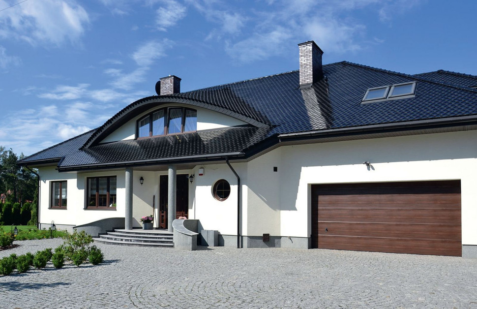 Dom z dachem pokrytym efektowną angobowaną dachówką ceramiczną typu karpiówka, w kolorze czarnym