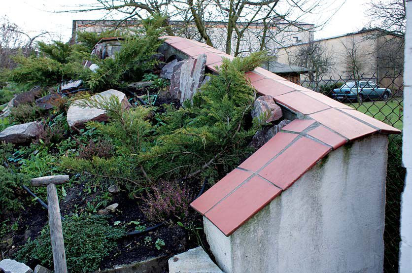 Mur podpiera sztuczną skarpę, na której urządzono skalniak