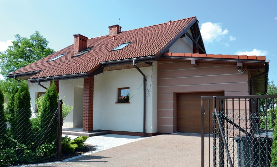 Zwarta bryła, boniowanie na ścianach, wybrukowane kostką betonową nawierzchnie komunikacyjne