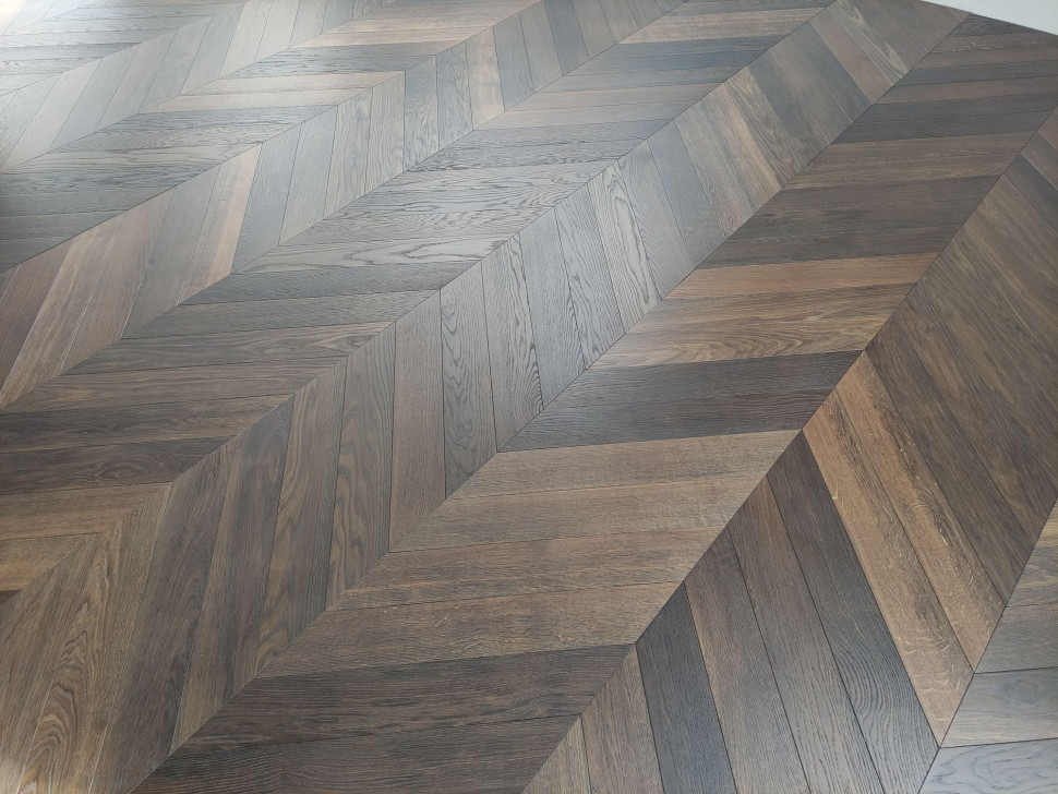 Ciemna podłoga z litego drewna wędzonego - ułożona w jodełkę. fot. Drymar