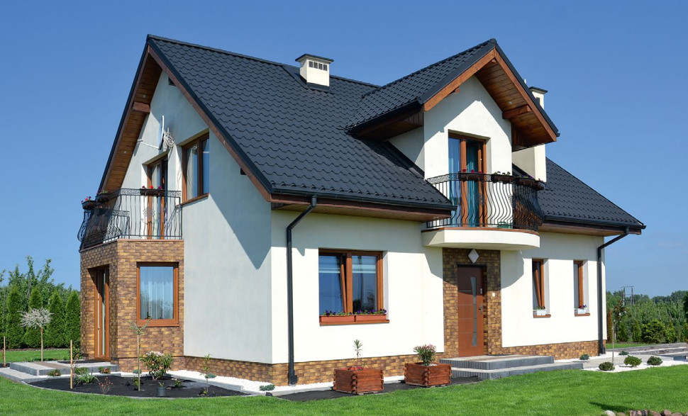 Bryłę domu urozmaica ganek i dodany wykusz z balkonem, które podkreślono okładziną z klinkieru