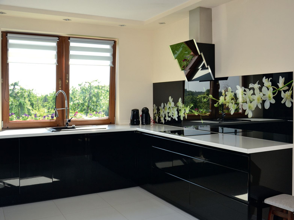 Kuchnia wyposażona w nowoczesną zabudowę w kolorze białym i czarnym, z kuchenką indukcyjną