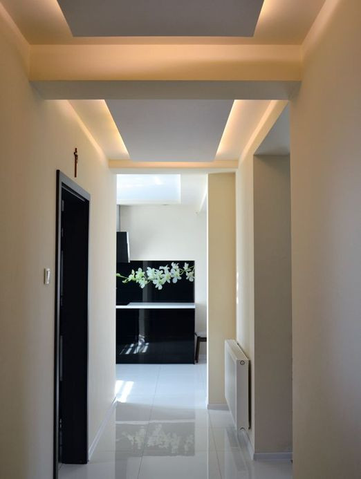 Korytarz w strefie dziennej ma w podwieszanym suficie dekoracyjne oświetlenie z taśmy LED