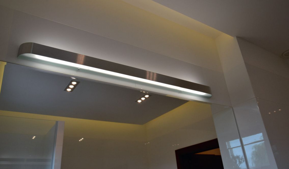 W łazience dzieci subtelną ciepłą iluminację tworzą taśmy LED, a intensywną - halogeny i podłużna oprawa nad lustrem