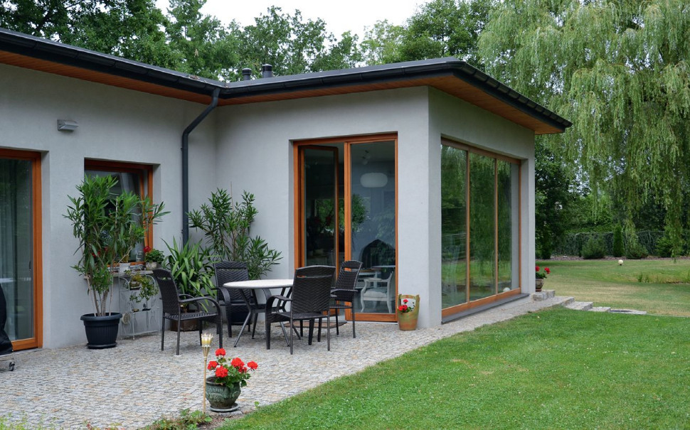 Niezadaszona wąska część tarasu przylega do kuchni i mieści mały komplet mebli kawowych