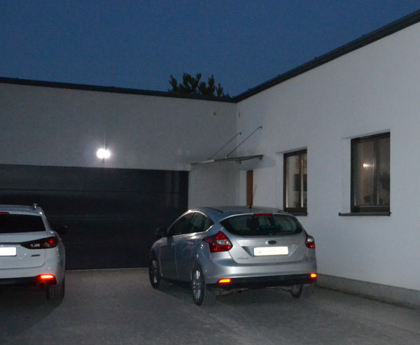 Reflektor halogenowy nad garażem współpracuje z czujnikiem zmierzchu