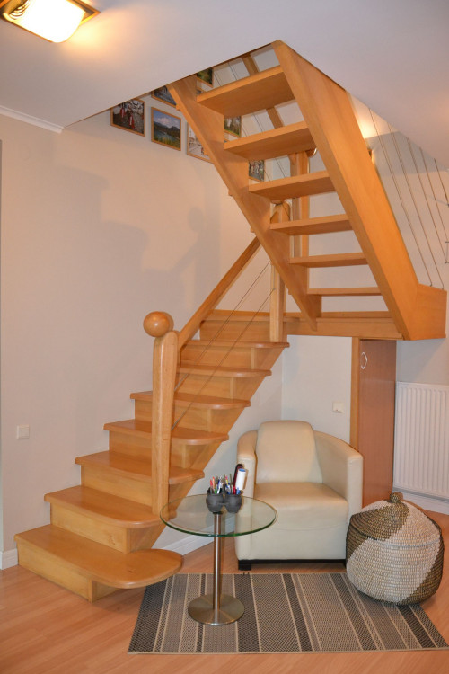 Schody wykonano z drewna bukowego. Dolny bieg ma pełne stopnie, górny jest ażurowy