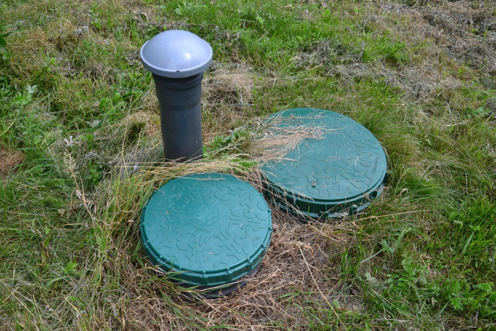 Pod pokrywami znajdują się: komora z zanurzeniowym złożem biologicznym i zintegrowana skrzynka sterująca (za częściami elektrycznymi)