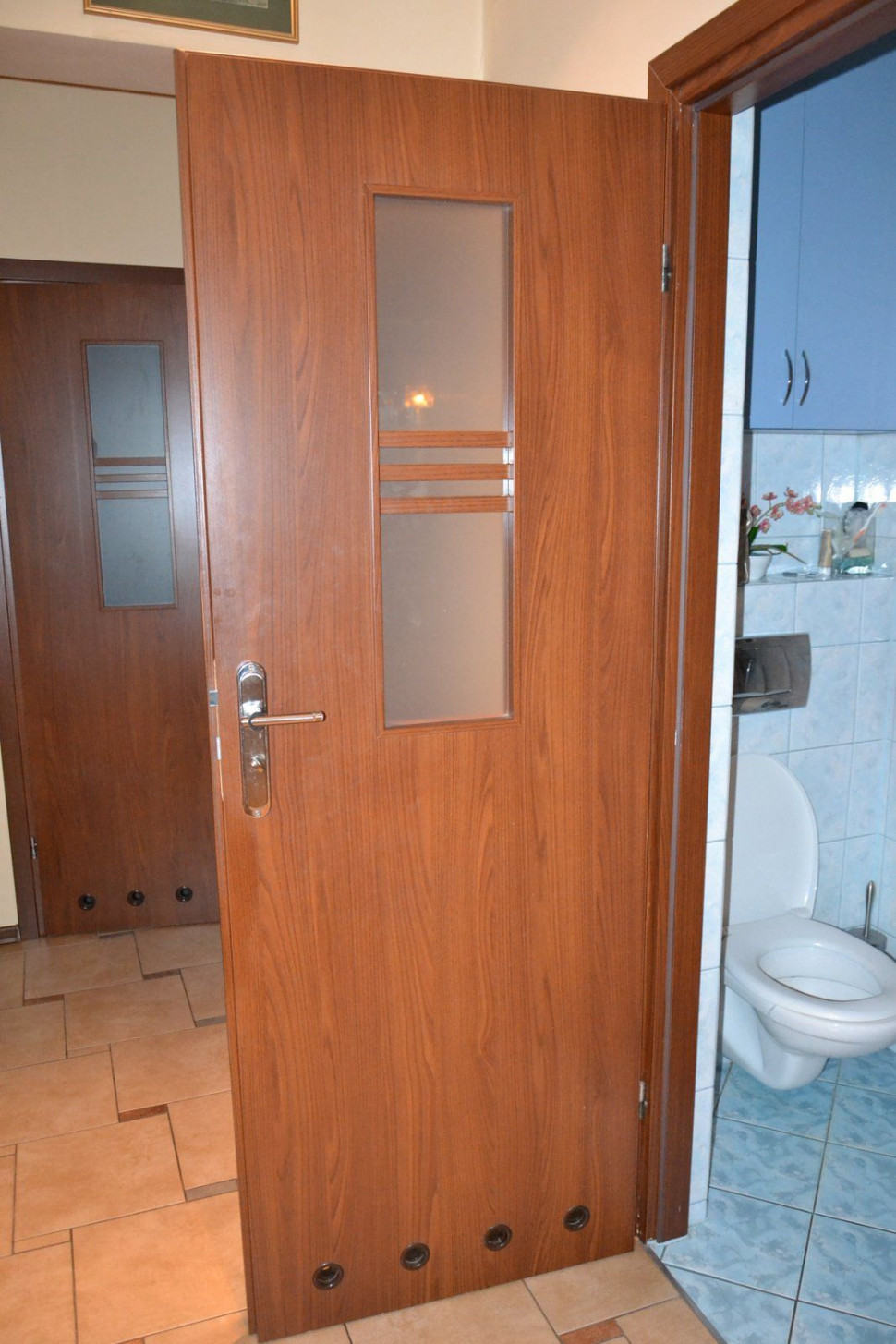 W drzwiach do łazienek szyba sięga do połowy wysokości skrzydła i zaopatrzono je w otwory wentylacyjne