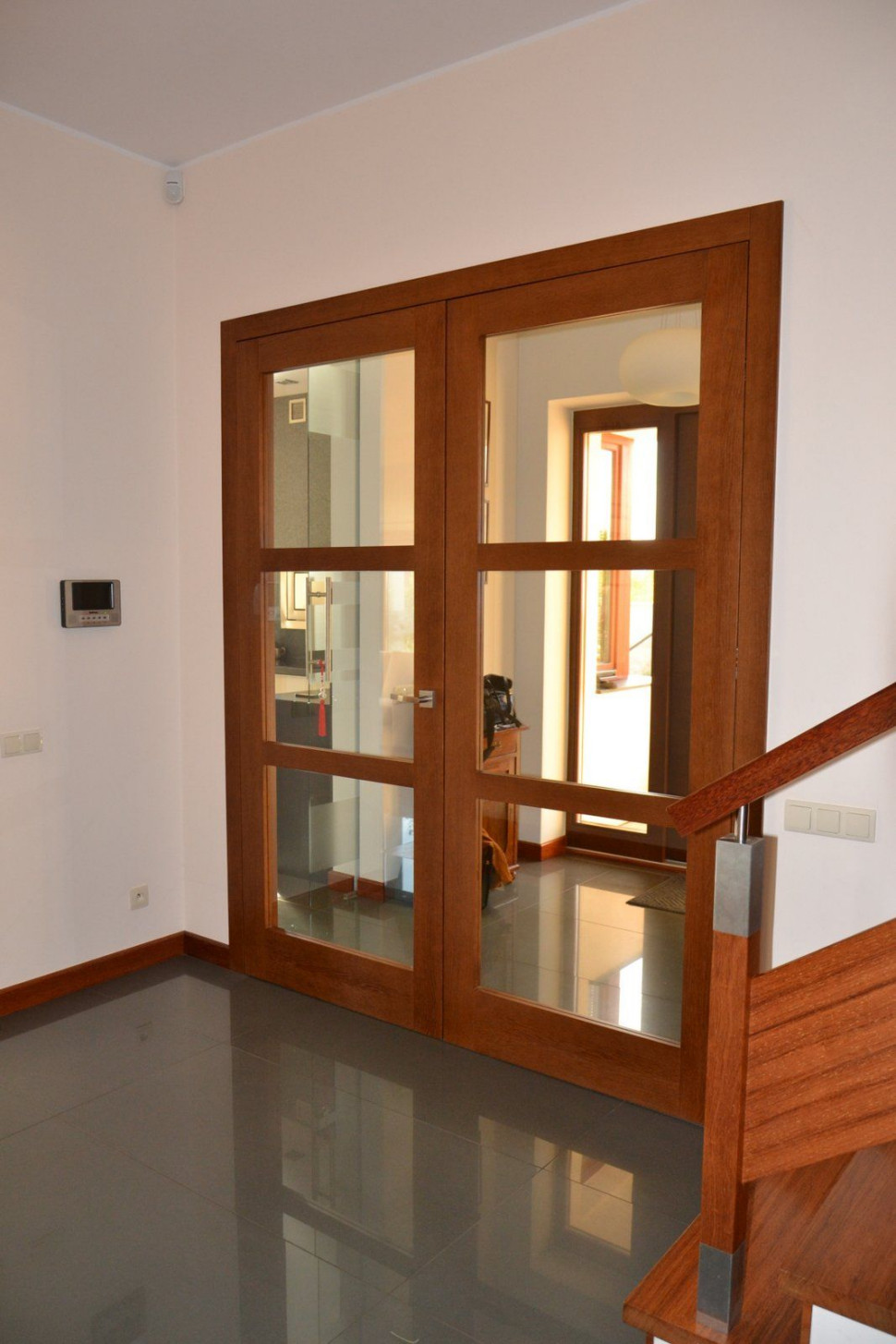 Dwuskrzydłowe drzwi z podziałami i szkłem stanowią ozdobę reprezentacyjnego holu